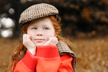 A Thoughtful Girl in a Plaid Cap Enjoys a Peaceful Autumn Day in a Golden Field While Dreaming