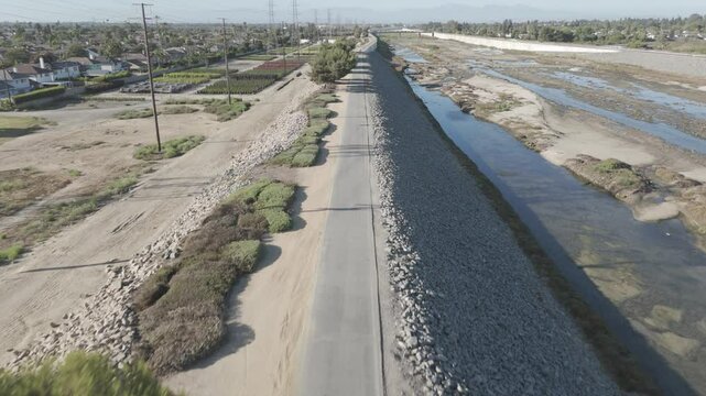 bike path on a gravel steep with ponds and greenery around, on a sunny day in Fairview Park