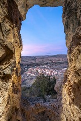 Scenic town view through rock window at sunset