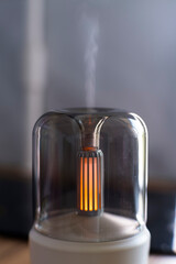 Air humidifier. Aroma lamp. Oils. Minimalism. Minimalistic lamp for air humidification. Horizontal. Vertical. Advertising. Meditation. Incandescent lamp. White case. Wireless aroma lamp. Close-up. 