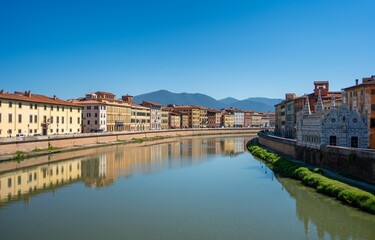 Obraz premium Scenic view of Arno River and historic buildings in Pisa, Italy.