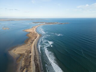 Fototapeta premium Aerial view of a coastal landscape with sandy beach and blue ocean