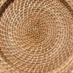 Circular pattern of the inside of an orange wicker bowl, top-down view, for background or texture with motifs of handicrafts, design and decor, aesthetics