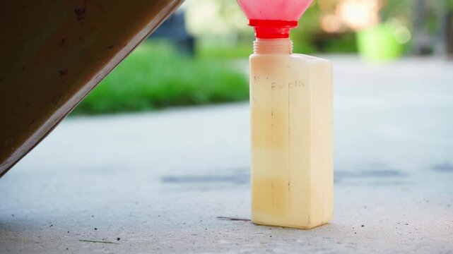 Gasoline is poured into the measuring canister for fuel mixing according to the mark