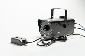 A black device with a cord attached to it. The cord is plugged into a wall outlet. The device is a fog machine