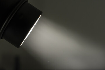 In a dark room, a directed beam of light. The beam of light is visible in the Dark room.