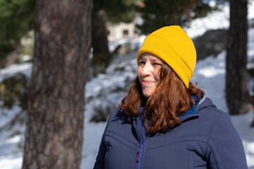 Caucasian woman smiling in a snowy forest on a sunny winter day