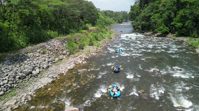 Drone view of people rafting on Sarapiqui River
surrounded by dense forests on a cloudy day