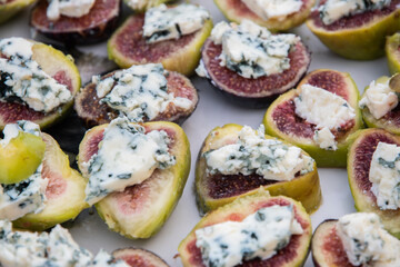 Ripe figs cut in half with a slice of blue cheese on top