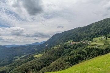 Naklejka premium Picturesque mountain landscape with scattered houses, and lush greenery, Jamnik Slovenia.