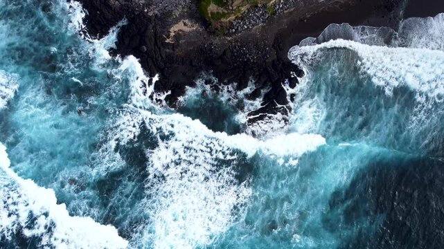 Aerial view of powerful waves crashing on the rocky coastline of Acores, Portugal.