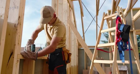 Carpenter Framing New Wall Structure in Residential Home During Daylight Hours