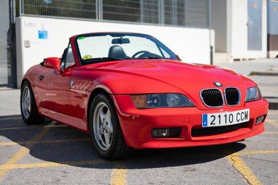 nice modern classic sports car, it is the red BMW Z3 convertible parked on the street