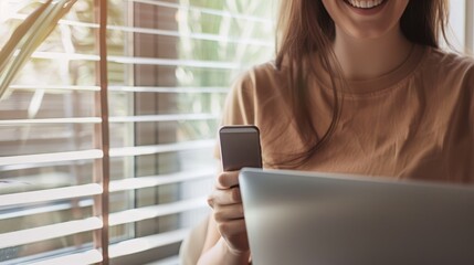 Fototapeta premium Smiling woman using phone and laptop