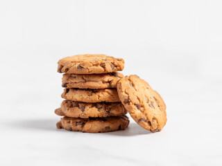 stacked chocolate chip cookies on white background