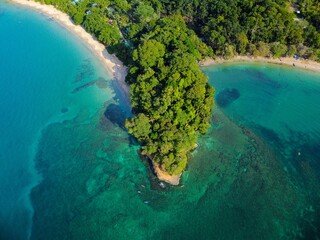 View of a lush green island surrounded by clear turquoise waters in Punta Uva beach