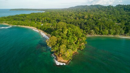 Alush green tropical island surrounded by turquoise waters and dense forest in Punta Uva beach