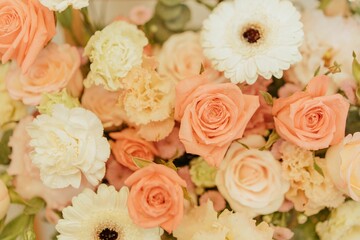 Close-up of a beautiful flower arrangement with peach roses and white carnations.