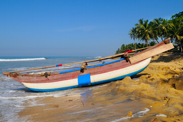 fishing boats on a long sandy beach on the ocean coast of Sri Lanka. © alinamd