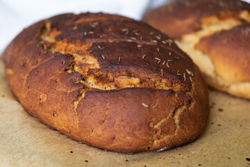 close up for two fresh baked rye bread loafs on a baking paper