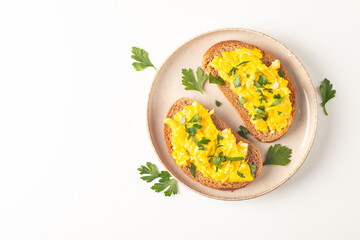 Scrambled eggs with green herbs on wheat-rye crispy toast.