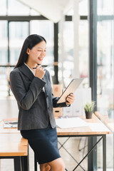 Professional woman smiling while using tablet in modern office