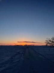 A prairie sunset over a snow filled field