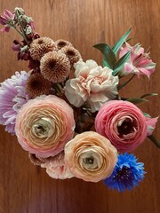 A floral bouquet of assorted pink, coral, peach and purple flowers.