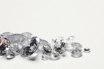 Many beautiful shiny diamonds on white background, closeup. Space for text