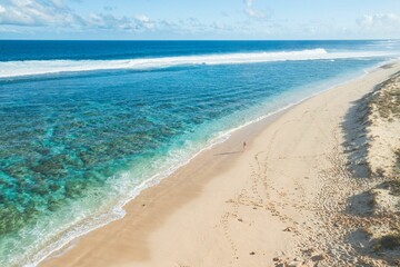 Aerial view of a pristine beach with clear turquoise water.