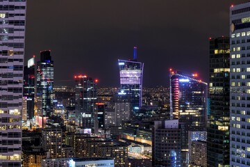 Obraz premium Night view of the cityscape featuring modern skyscrapers illuminated