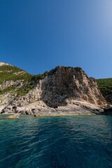 Scenic view of green coastal cliffs and blue waters of Zakynthos Island in Greece on a sunny day
