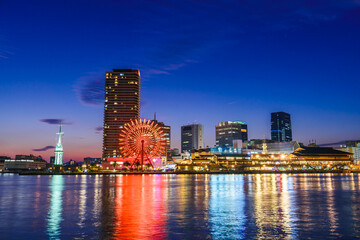 Fototapeta premium Kobe port with view of ferris wheel and shopping mall at twilight.