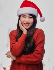 Portrait of beauty Asian woman wearing Santa-Claus hat with happy expression for Christmas celebration on bright background