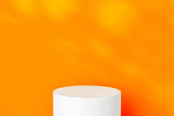 White cylindrical display on a bright orange background