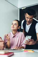 Smart colleagues working at table in office