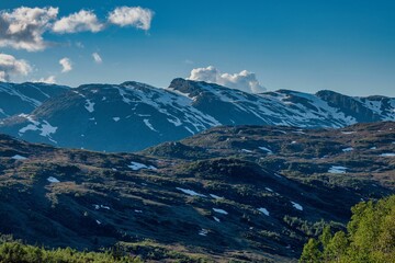 Fototapeta premium Snow-capped mountains under a clear blue sky.