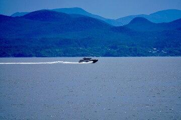 Speedboat cruising on a lake with mountain backdrop