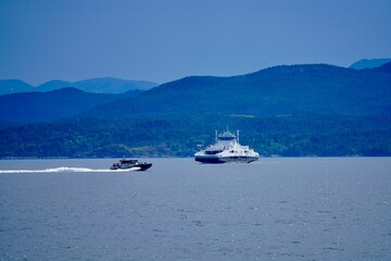 Obraz premium Boats cruising on a calm sea with mountains in the background