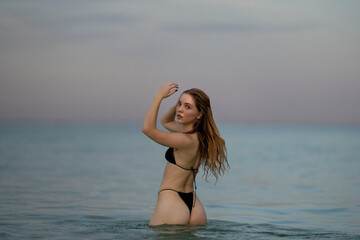 Photo of beautiful sexy woman in bikini relaxing on summer beach. Young sexy woman in bikini posing...