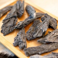 Close-up of black wood chips on a wooden tray