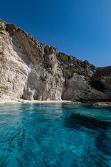 Fototapeta premium Vertical view of the blue waters reflecting majestic coastal cliffs in Zakynthos island, Greece