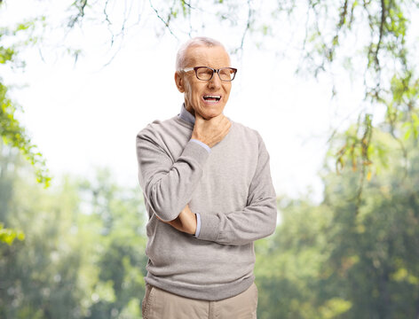 Elderly man with a sore throat standing outdoors
