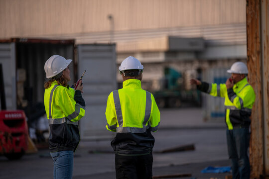Engineer or worker standing forklift or truck vehicle are holding detail and appear to be discussing or reviewing documents, likely related to inspect about factory and industry worksite.