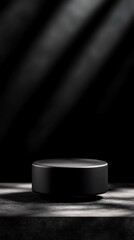 Minimalistic black pedestal illuminated by dramatic lighting on a dark background, perfect for showcasing products or artwork.