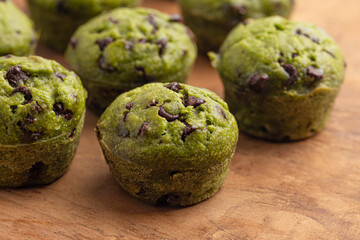Healthy Green Spinach Hidden Vegi Chocolate Chip Mini Muffins on a Wooden Table
