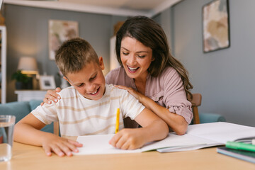 Mother and Son Sharing a Joyful Homework Session in a Comfortable Living Room