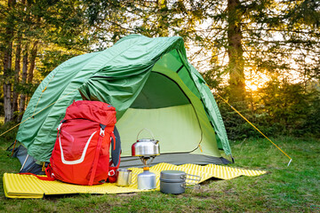 Camping with a tent and cooking equipment in the mountains.