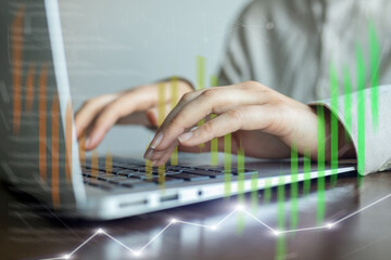 A person is typing on a laptop with a green line on the screen