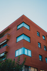 An eyecatching and striking building that showcases a contemporary red brick facade along with artistic windows in Tarragona, Spain